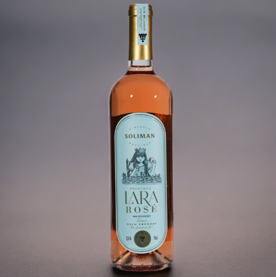 Um Tributo à Delicadeza. O Rosé Princesa Lara é uma homenagem terna e encantadora à pequena Lara, filha de Rogério e Vanessa Soliman, e um tributo à tradição vinícola do Alto Uruguai, RS. Criado à moda italiana, este vinho reflete a alma de 16 castas italianas, prensadas com maestria e fermentadas sob controle rigoroso, resultando em um rosé único e inesquecível.